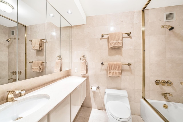 45 E 80th St Unit 17B, New York City, NY 10075 - bathroom featuring tile walls, bath / shower combo with glass door, tile patterned flooring, toilet, and vanity