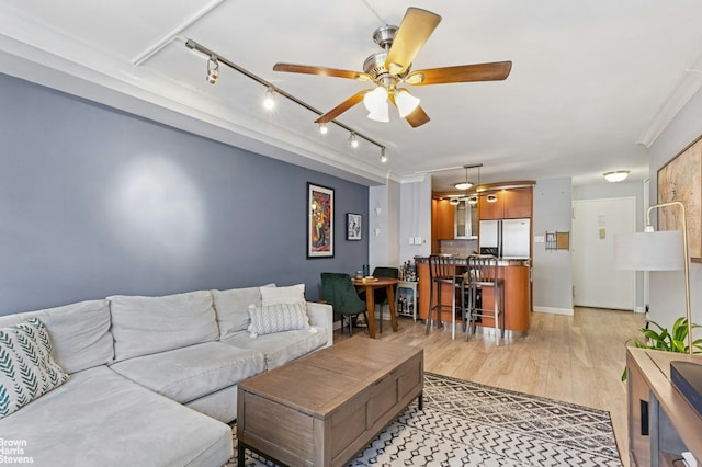 living area with track lighting, light wood-type flooring, and ceiling fan