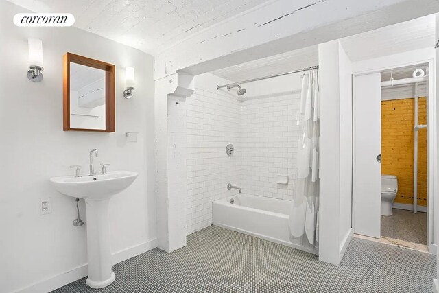 53 Crosby St Unit 1, New York City, NY 10012 - full bathroom featuring toilet, shower / bath combination with curtain, and baseboards