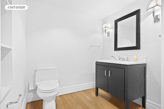 53 Crosby St Unit 1, New York City, NY 10012 - bathroom with toilet, vanity, wood finished floors, and baseboards