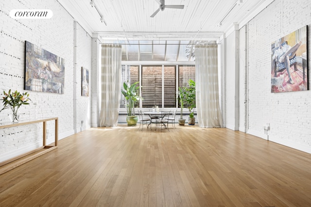 53 Crosby St Unit 1, New York City, NY 10012 - interior space with brick wall, hardwood / wood-style flooring, rail lighting, ceiling fan, and a wall of windows