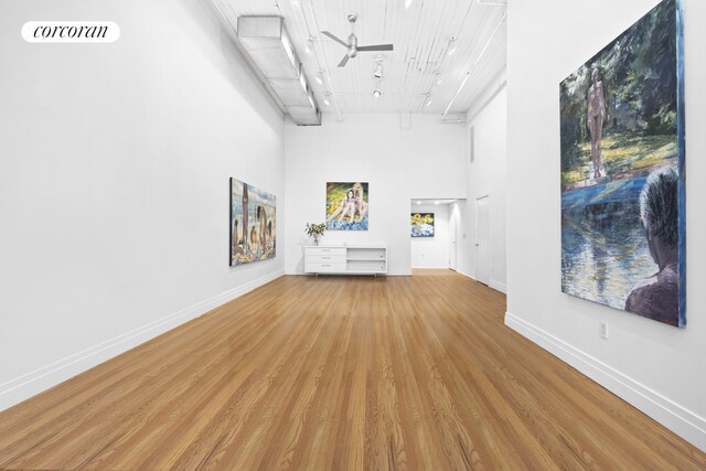 53 Crosby St Unit 1, New York City, NY 10012 - unfurnished living room with wooden ceiling, ceiling fan, baseboards, a towering ceiling, and wood finished floors