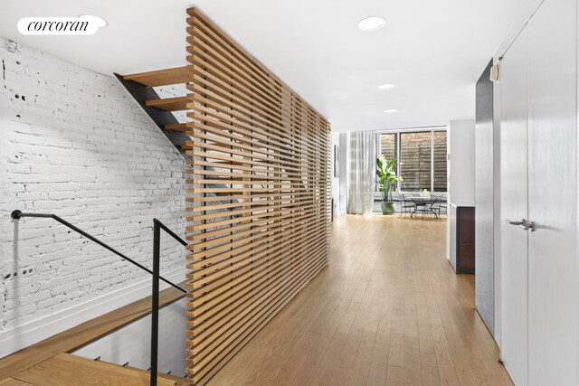 53 Crosby St Unit 1, New York City, NY 10012 - corridor featuring recessed lighting, brick wall, an upstairs landing, light wood-type flooring, and floor to ceiling windows