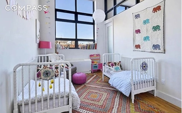 360 Furman St Unit 511, New York City, NY 11201 - bedroom featuring multiple windows, wood finished floors, and baseboards