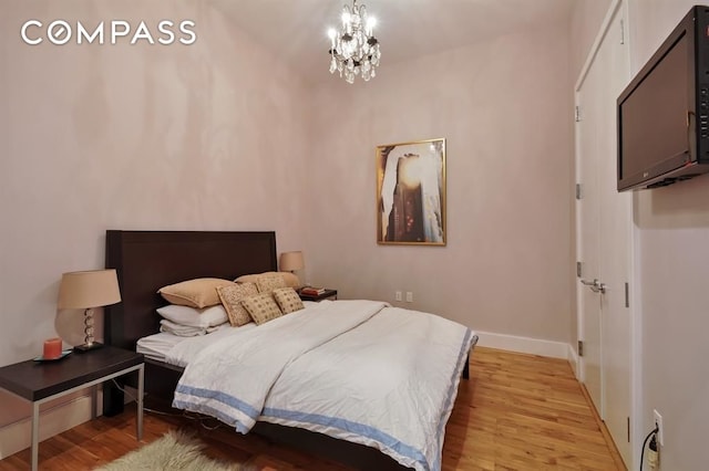 360 Furman St Unit 511, New York City, NY 11201 - bedroom with light wood-style floors, a chandelier, and baseboards