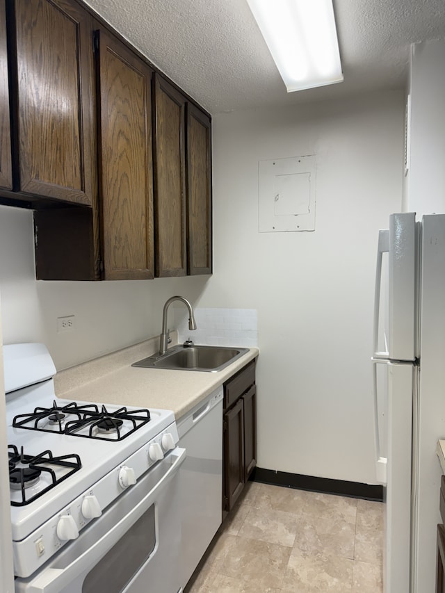 2025 Broadway Unit 23G, New York City, NY 10023 - kitchen with white appliances, a sink, dark brown cabinets, light countertops, and baseboards