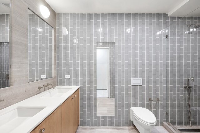 full bath featuring tile walls, toilet, and a sink