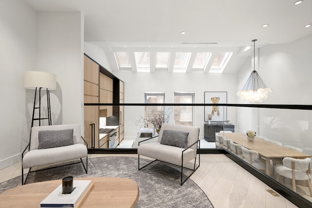living area featuring recessed lighting, a skylight, a notable chandelier, and baseboards