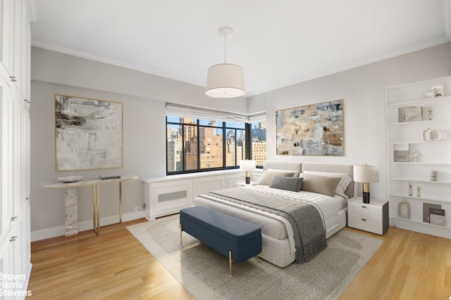 bedroom featuring light wood finished floors, baseboards, and ornamental molding