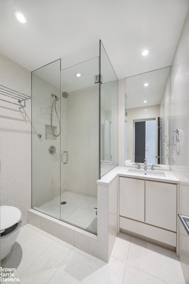 bathroom featuring recessed lighting, toilet, vanity, and a stall shower