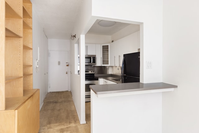 kitchen with stainless steel appliances, white cabinetry, a peninsula, glass insert cabinets, and light colored carpet