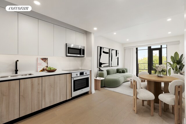 kitchen featuring a sink, modern cabinets, open floor plan, stainless steel appliances, and visible vents