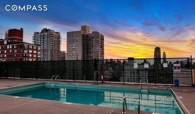 370 E 76th St Unit C1208, New York City, NY 10021 - pool at dusk featuring a view of skyline and a community pool