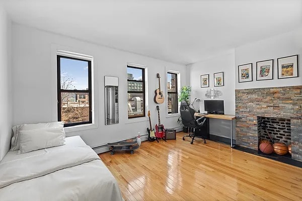 bedroom with light wood finished floors and a fireplace