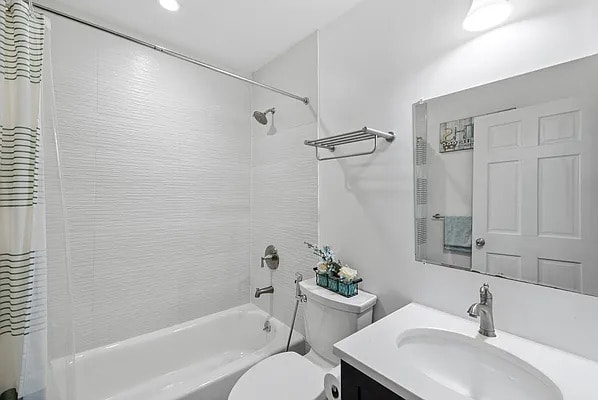 bathroom with vanity, toilet, and shower / tub combo