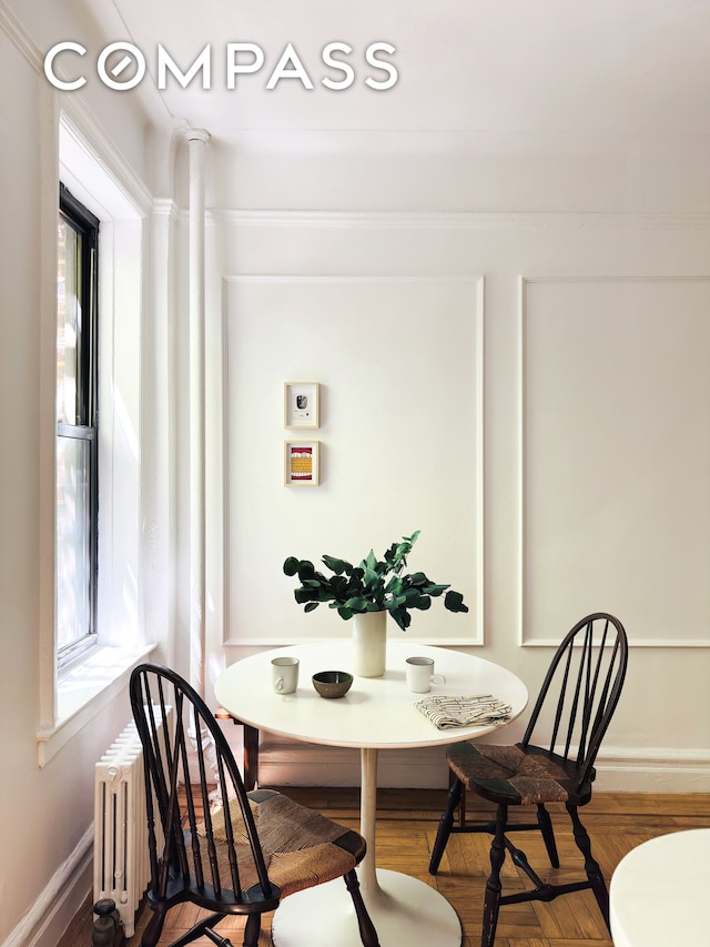 dining room featuring baseboards, plenty of natural light, and radiator