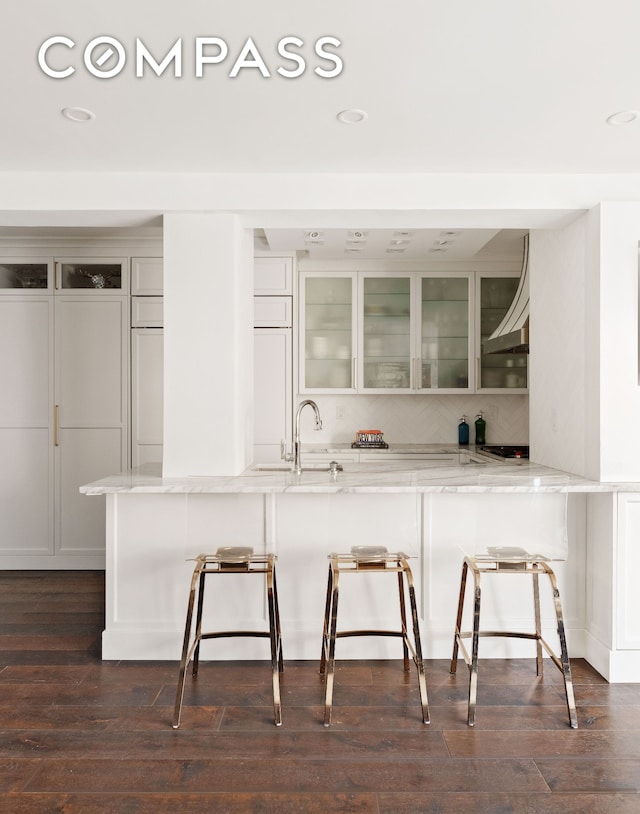 11 5th Ave Unit 8Ab, New York City, NY 10003 - kitchen with a breakfast bar, recessed lighting, glass insert cabinets, light stone counters, and tasteful backsplash