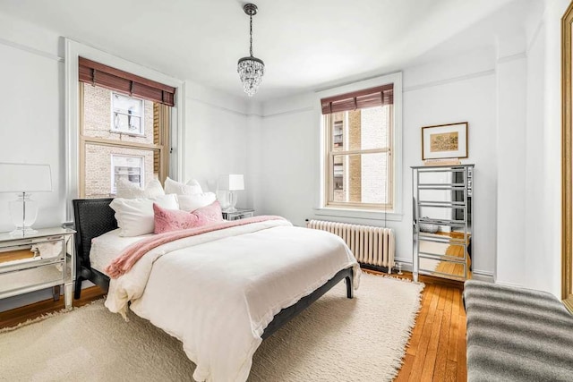 390 Riverside Dr Unit 6D, New York City, NY 10025 - bedroom featuring radiator heating unit, multiple windows, and wood finished floors