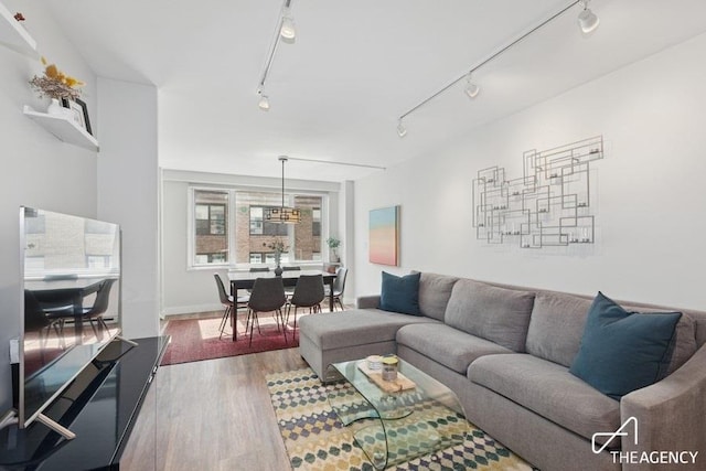 living area with wood finished floors and track lighting