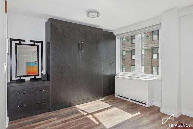 unfurnished dining area with wood finished floors and baseboards