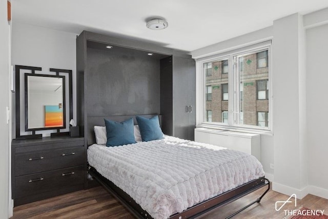 bedroom with wood finished floors and baseboards