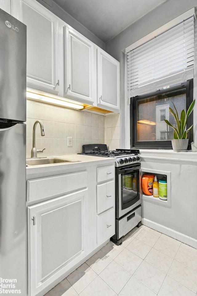 kitchen featuring a sink, light countertops, backsplash, and stainless steel appliances