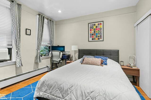 345 E 77th St Unit 3F, New York City, NY 10075 - bedroom featuring a baseboard radiator, wood finished floors, and recessed lighting