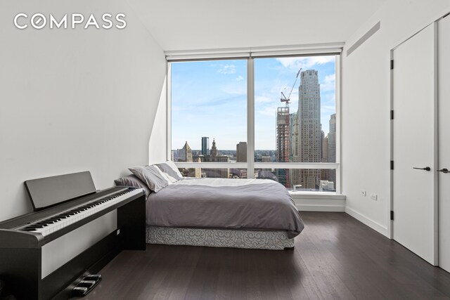 111 Murray St Unit 43B, New York City, NY 10007 - bedroom featuring a skyline view, multiple windows, floor to ceiling windows, wood finished floors, and baseboards