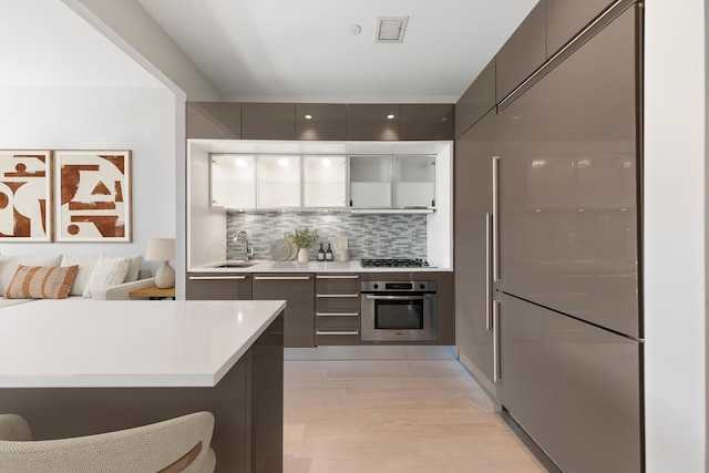 75 Wall St Unit 28-Q, New York City, NY 10005 - kitchen with stainless steel appliances, modern cabinets, tasteful backsplash, and light countertops