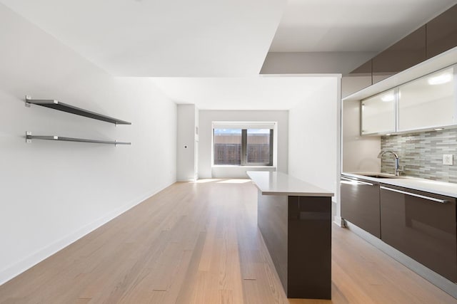 75 Wall St Unit 28-Q, New York City, NY 10005 - kitchen featuring modern cabinets, a sink, backsplash, and light countertops