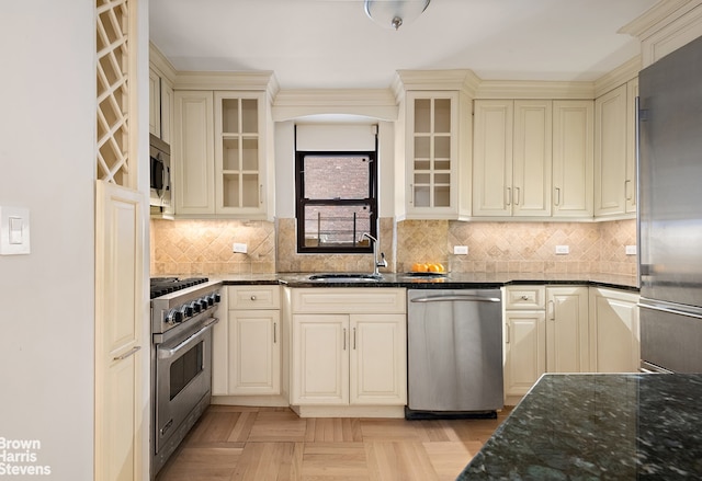 30 E 37th St Unit 4Hj, New York City, NY 10016 - kitchen with high quality appliances, cream cabinets, dark stone counters, and tasteful backsplash