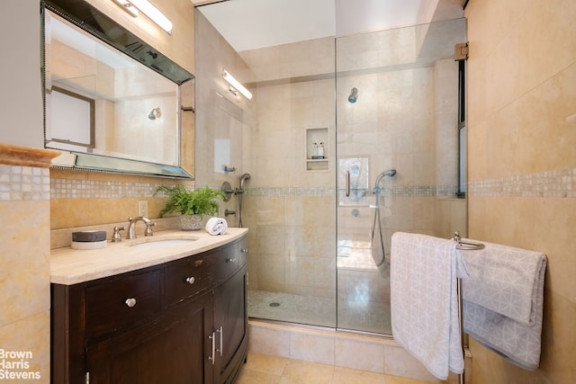 30 E 37th St Unit 4Hj, New York City, NY 10016 - bathroom featuring tile walls, vanity, a stall shower, and tile patterned flooring