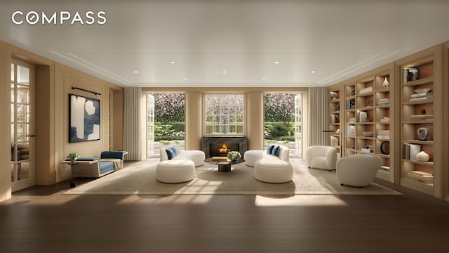 living area featuring a lit fireplace, built in shelves, wood finished floors, and crown molding
