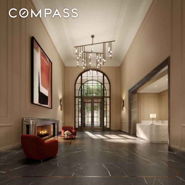 lobby with a decorative wall, a high ceiling, and ornamental molding