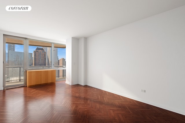 spare room featuring baseboards and a skyline view
