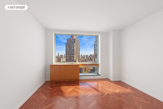 spare room with baseboards and a city view