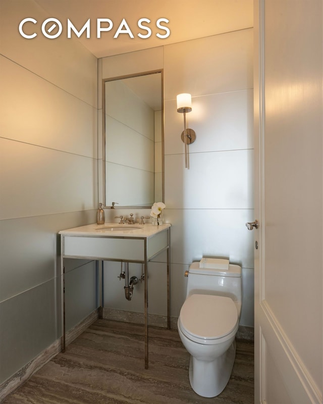 40 E 66th St Unit 9A, New York City, NY 10065 - bathroom featuring wood finished floors, toilet, and a sink