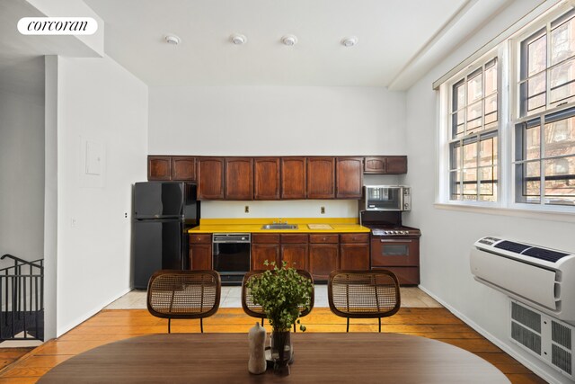 234 E 35th St Unit 5, New York City, NY 10016 - kitchen featuring black appliances, light wood-type flooring, a sink, baseboards, and light countertops