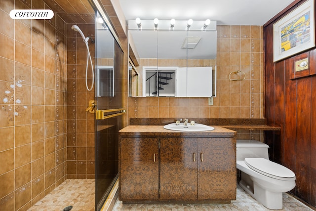 full bathroom with tile walls, toilet, a shower stall, vanity, and decorative backsplash