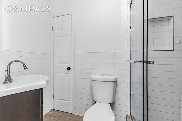 full bathroom with vanity, a stall shower, and tile walls