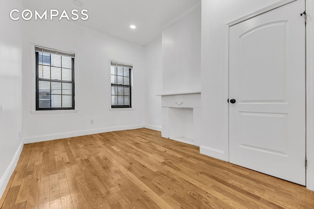 unfurnished living room featuring recessed lighting, baseboards, and light wood-style floors