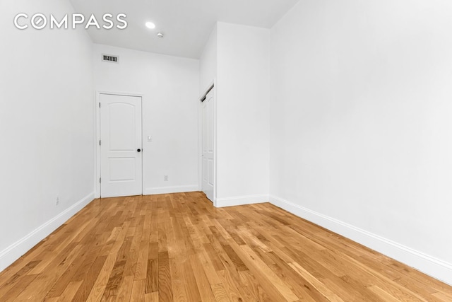 spare room featuring visible vents, light wood-style floors, and baseboards
