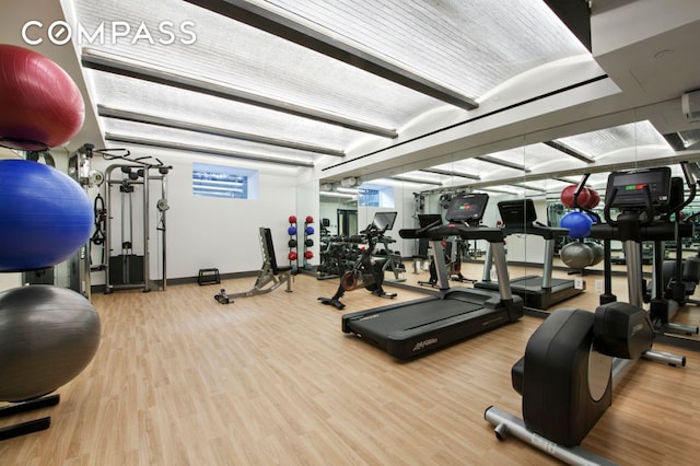 exercise room with wood finished floors and baseboards