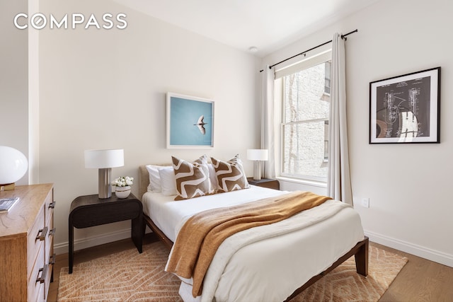 bedroom featuring light wood-style floors and baseboards