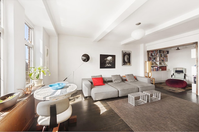 living room featuring beamed ceiling and wood finished floors