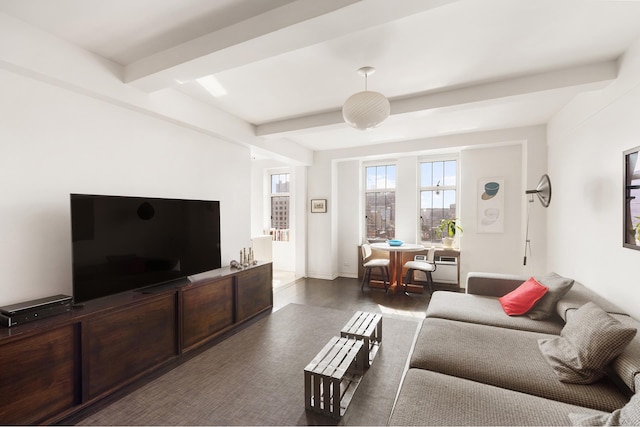 living area with beam ceiling and wood finished floors