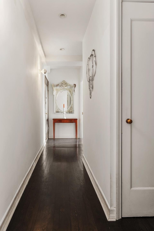 hallway with wood-type flooring and baseboards