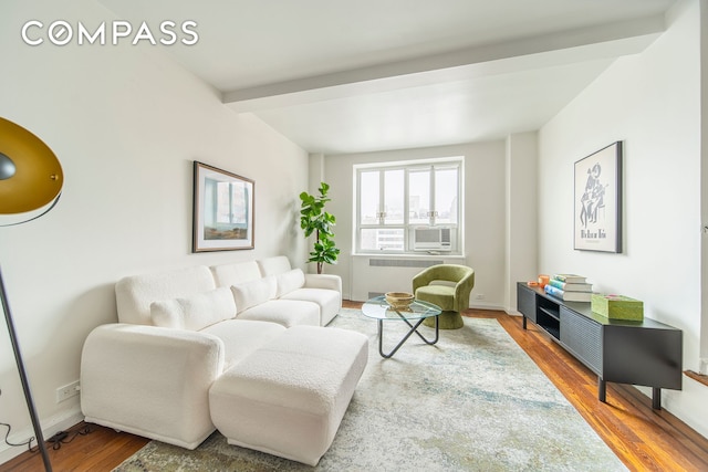 living area featuring radiator heating unit, wood finished floors, baseboards, beam ceiling, and cooling unit