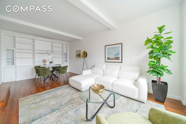 living room featuring beamed ceiling, wood finished floors, and baseboards