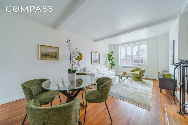 dining space featuring beam ceiling, wood finished floors, radiator, and baseboards